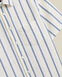 Chemise Piquet Stripe Bleue Portuguese Flannel. Détail du motif rayé bleu sur tissu piqué blanc cassé, avec boutons et poche.