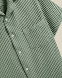 Chemise Cornelius Portuguese Flannel en tissu gaufré vert sauge. Chemise à manches courtes avec col, boutons et poche poitrine.