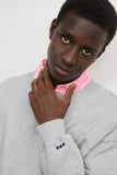 Sweat Crewneck Gris LATER porté par un homme avec une chemise rayée rose et des détails brodés.