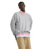 Homme portant le Sweat Crewneck Gris LATER..., chemise rayée rose et short kaki, baskets blanches. Look streetwear décontracté.