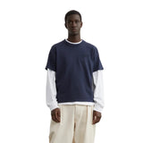 T-shirt Essentiel Hortensia Marine LATER porté par un homme, avec t-shirt blanc ML, pantalon plissé beige et chaussures noires.