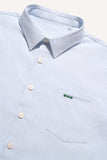 Surchemise ÉPURE Marine LATER... à rayures fines bleu clair et blanc, col, boutons clairs et logo brodé vert sur poche poitrine.