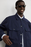 Blouson Worker Marine LATER... porté par un homme souriant en lunettes de soleil, chemise rayée, main dans la poche.
