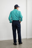 Homme de dos portant la Chemise HEOL Rayures Vertes LATER, un pantalon marine et une casquette.