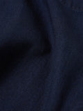 Gros plan sur le tissu denim à chevrons indigo de la Smock Overshirt Universal Works. Tissage en herringbone offrant une texture raffinée et un toucher agréable. Un vêtement robuste qui se patine avec le temps. À découvrir en boutique chez SEE YOU à Versailles.