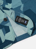 Gros plan sur le coton texturé et le motif camouflage suédois revisité de la Merchant Jacket Blue Swedish Camo Universal Works. Impression unique en nuances de bleu pour une allure audacieuse et tendance. Disponible en exclusivité chez SEE YOU à Versailles.