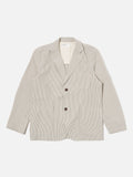 Two Button Jacket Grey Derby Stripe Universal Works, veste élégante et minimaliste avec une coupe ajustée. Tissu texturé à fines rayures grises pour un look intemporel et raffiné. Fermeture à deux boutons pour une allure moderne et structurée. Disponible exclusivement en boutique chez SEE YOU, concept store à Versailles.