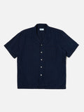 Road Shirt Indigo Herringbone Denim Universal Works, chemise en denim à chevrons avec une coupe droite et un col ouvert. Teinte indigo profonde pour un look intemporel et authentique. Disponible dans notre concept store homme à Versailles.
