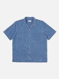 Road Shirt Washed Indigo Herringbone Denim Universal Works, chemise légère en denim à chevrons. Coupe droite et col ouvert pour une allure décontractée et élégante. Teinte indigo délavée, offrant un look vintage et authentique. Disponible dans notre concept store homme à Versailles.
