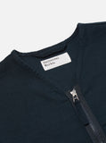 Détail du col sans fioritures et de la fermeture zippée bidirectionnelle de la Zip Liner Jacket Navy Slub Sateen Universal Works. Une veste fonctionnelle au design épuré, idéale pour un look urbain ou casual chic. Disponible en exclusivité chez SEE YOU, concept store à Versailles.