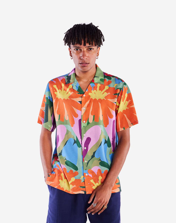 Chemise Aloha Wildflowers OLOW portée par un modèle. Coupe fluide et imprimé floral pour une allure estivale affirmée. À porter ouverte sur un t-shirt ou fermée avec un short ou un jean. Disponible en boutique chez SEE YOU à Versailles.