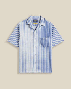 Chemise à manches courtes Jacquard rayé Chambray Portuguese Flannel – coupe droite, tissu chambray à rayures jacquard subtiles. Une pièce estivale élégante et légère, à découvrir chez SEE YOU, concept store à Versailles.
