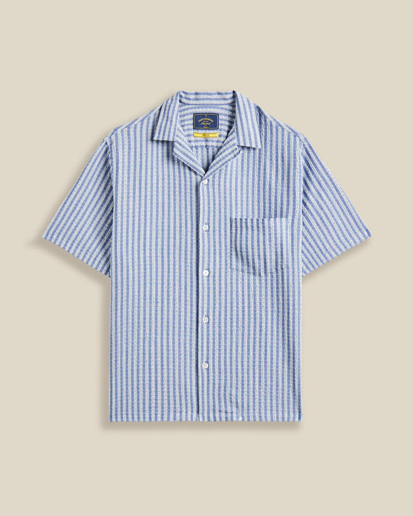 Chemise à manches courtes Jacquard rayé Chambray Portuguese Flannel – coupe droite, tissu chambray à rayures jacquard subtiles. Une pièce estivale élégante et légère, à découvrir chez SEE YOU, concept store à Versailles.
