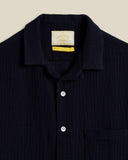 Col camp ouvert pour un style rétro et estival, boutons nacrés discrets pour une finition raffinée. Chemise disponible chez SEE YOU à Versailles.