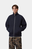 Pull zippé Banley Carhartt WIP bleu marine foncé en maille côtelée, porté par un homme avec un pantalon camouflage.