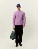 Pull Col Rond Douceur Oyster Rose Melange Les Deux porté par un homme avec pantalon foncé, casquette marine et sac de sport vert.