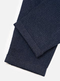 Super Chino Bobby Wool Mix Marine à Carreaux. Tissu bleu marine en laine mélangée à motif de petits carreaux gris, plié.