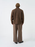 Veste polaire en laine Rams marron chiné Universal Works, vue de dos, portée avec un pantalon marron et des chaussures noires.