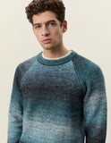 Homme portant le pull col rond dégradé Mediterranea Green Les Deux, avec des tons bleu-vert foncés et clairs.