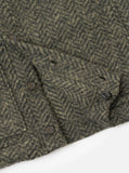 Zoom sur le cardigan Universal Works Advance Raven Fleece Olive: tissu molletonné vert à motif chevrons avec boutons.