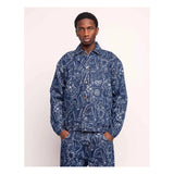 Veste Akka Life Dance Olow, veste en jean bleue avec des motifs abstraits blancs, portée par un homme.