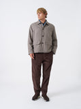 Homme portant le pantalon Military Chino Cord Universal Works en velours côtelé cacao, associé à une veste à carreaux.
