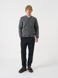 Cardigan Universal Works en laine polaire gris chiné porté par un homme, avec chemise claire, pantalon noir et baskets.