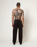 Jean Carotte Jabali Apache Cocoa HOMECORE sur homme de dos avec tatouages et ceinture en cuir.